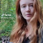 September is over! I've posted a video to recap my reading for the month. Still image shows me (white woman with long red hair) standing in my backyard with trees behind me, holding my giant tea mug.