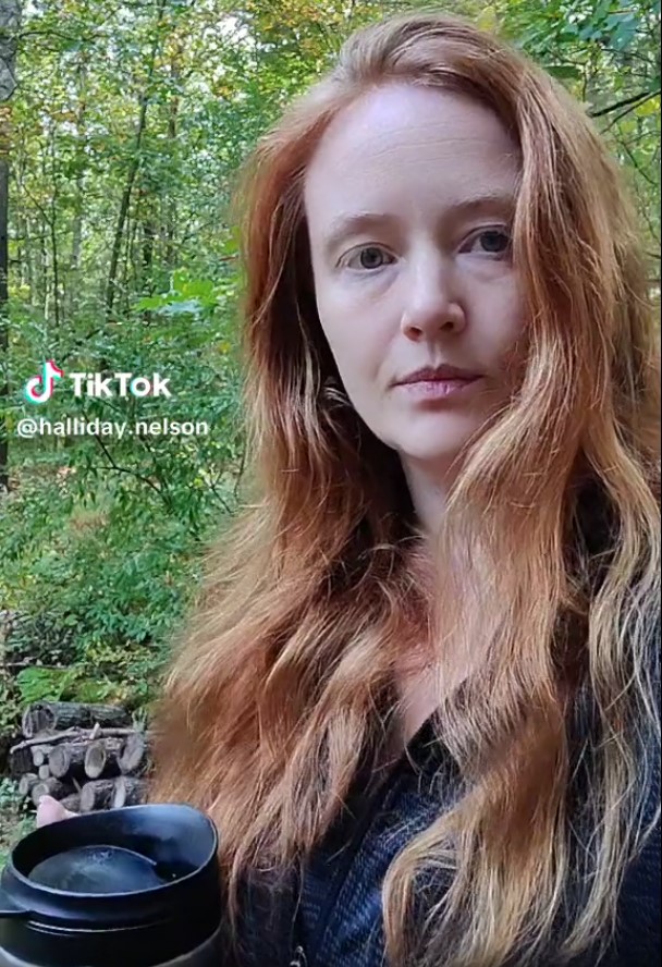 September is over! I've posted a video to recap my reading for the month. Still image shows me (white woman with long red hair) standing in my backyard with trees behind me, holding my giant tea mug.